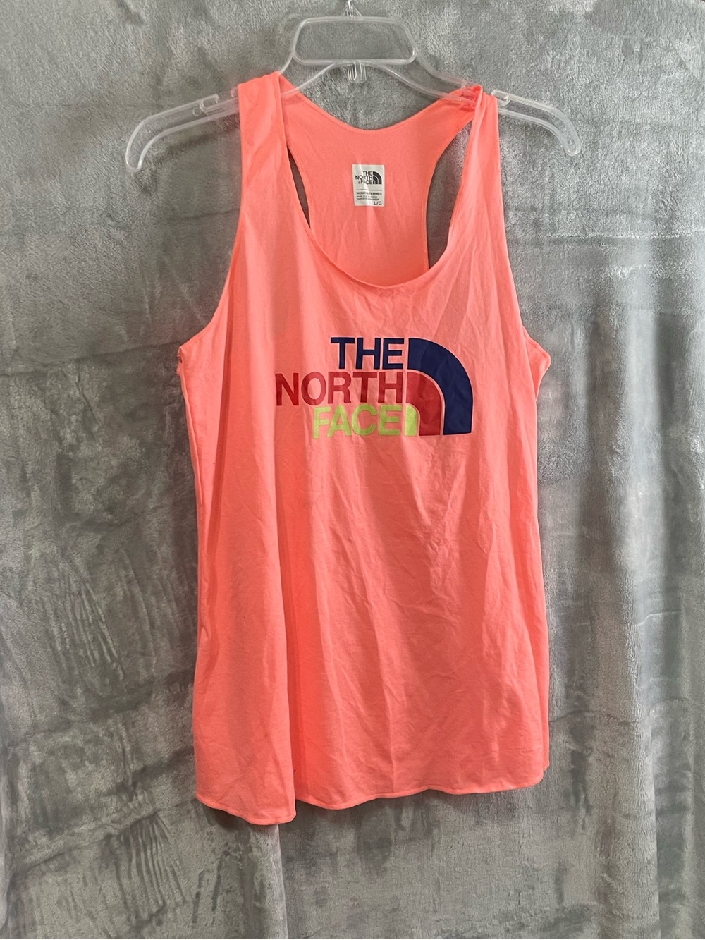 bright orange The North Face sleeveless tank top multi-color logo graphic chest
